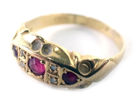 An 18ct gold ruby and diamond gypsy ring, the boat shaped ring head set with three round brilliant cut rubies and four round brilliant cut diamonds in petalated border, Birmingham 1920, ring size K½, 2g all in.