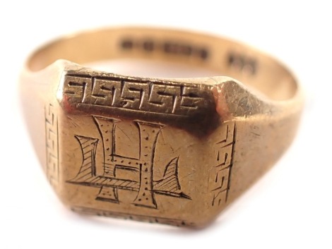 A George V 9ct gold signet ring, the rectangular ring head bearing the initials H.C, with Greek key border, Birmingham 1932, ring size R½, 4.4g all in.