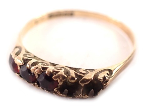 A 9ct gold dress ring, the panel set with five garnets (two missing) each round brilliant cut in claw setting, on thin worn band, ring size P, 1.2g all in. (AF)