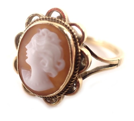 A 9ct gold cameo dress ring, the oval cameo depicting a maiden in sinister pose, in a rope twist and petal border on V splayed shoulders, maker A & Co, Birmingham 1978, ring size O½, 2.7g all in.