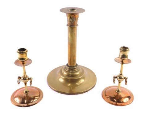 A pair of 19thC Arts and Crafts style copper and brass candlesticks, each with ring handles and engraved base, 18cm high, and a late 19thC brass oil lamp base, decorated with art nouveau hearts, 28cm high.