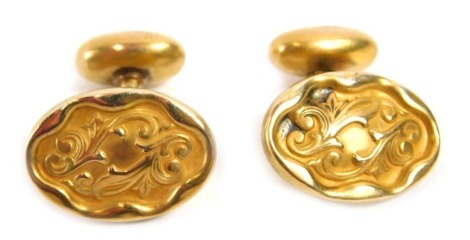 A pair of 19thC cuff links, of oval design with fluted border and scroll design central section, on a shaped and bowed back, gold coloured, stamped WGG.