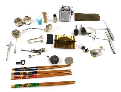 A group of curios and trinkets, comprising a pair of silver plated napkin rings, Art Nouveau cased brass tape measure, chopsticks, a French table lighter in Art Deco style, a shooting butt marker, crumb scoop, etc. (1 tray)