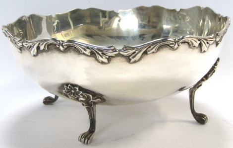 A George V silver bowl, the rim cast with leaves, etc., raised on four paw feet, with flower head and scroll decoration, Docker & Burn Ltd, Birmingham 1930, 24.28oz, 24cm diameter. (AF)