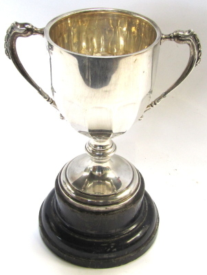 A George VI silver trophy cup, with swag reeded handles, engraved replica, Cooperative Wholesale Society Ltd, National Bakery Exhibition, Silver Championship Cup for Bread, awarded to JA Clayton 1937, Chester 1936, 24cm high, 10.44oz, on ebonised socle. - 2