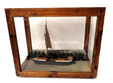 A scale model of a single masted barge, polychrome decorated with realistic base, in stained pine and perspex case, 67cm wide.