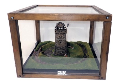 A diorama model of a Roman watch tower, with surrounding ditches, etc., in wood and perspex case, 47cm wide.