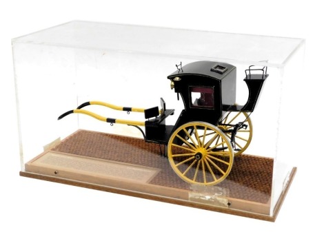 A scale model of an early Victorian Hanson cab, in black and yellow livery, in glazed wooden case, 50cm wide.