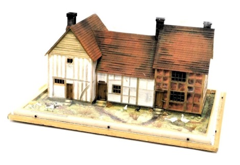 A diorama or model of three timber framed cottages, from circa 1500, 1400 and 1650, 60cm wide.