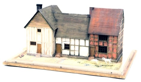 A model of three timber framed cottages, from 1500, 1400 and 1650, in a perspex and wooden case, 60cm wide.