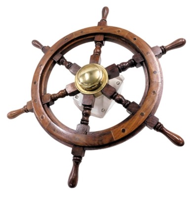 A wooden and brass ships wheel, 64cm diameter, mounted on a white painted metal stem, 23cm high.