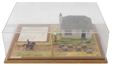 A diorama model of an 18thC toll house, with building, animals, figure of horseback and display of tolls, in Perspex and wooden case, 62cm wide.