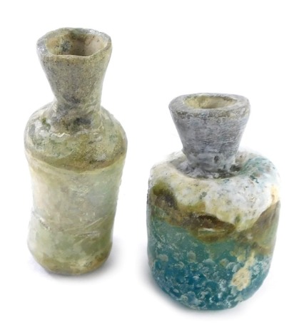 An excavated Roman glass bottle, 6.5cm high, and another 5.75cm high.