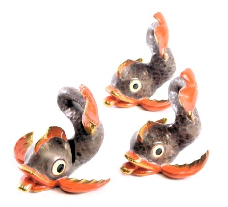 Three Herend of Hungary hand painted porcelain fish, on a brown and red gilded ground, 8cm high, one a menu holder. (3)