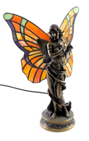 A Tiffany style table lamp, formed as a female with butterfly wings, on orange and yellow glass ground, on gilded stem, 29cm high, 26cm wide.