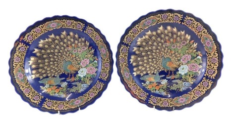 A pair of decorative Chinese chargers, signed WIWGG stamped China, on a blue ground with gilded decoration of peacocks, scrolls and flowers, 41cm diameter. (2)