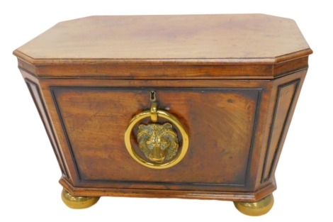 A George IV mahogany cellarette, the rectangular hinged top with canted corners, enclosing a lead lined interior, the base with a large brass lion mask handle, on brass bun feet, 66cm wide.