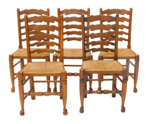 A set of five Lancashire type ladder back dining chairs, each with a rush seat on turned tapering legs.