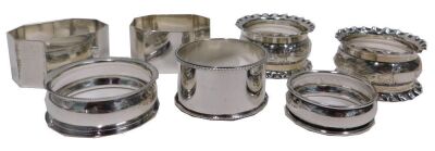 Seven silver napkin rings, comprising a pair of George V napkin rings with pie crust borders and scroll decoration, a pair of octagonal plain design napkin rings, etc., 4.21oz. (8)