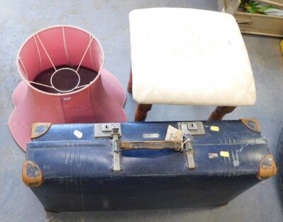 Blue suitcase, stool, and a pink lamp shade.