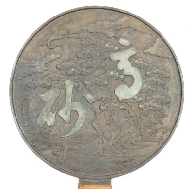 A Meiji period Kagami bronze hand mirror, the reverse embossed with a pine tree and cranes, and two characters, the handle bound in bamboo, signed, 27cm high, 18cm wide. - 2