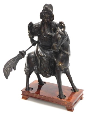 A 20thC Chinese bronze figure of Guan Yu, modelled on horseback, holding a guandao, on a wooden stand, 31cm high.