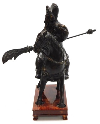 A 20thC Chinese bronze figure of Guan Yu, modelled on horseback, holding a guandao, on a wooden stand, 31cm high. - 3