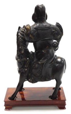 A 20thC Chinese bronze figure of Guan Yu, modelled on horseback, holding a guandao, on a wooden stand, 31cm high. - 4