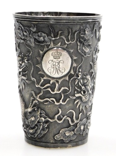 A Hung Chong silver beaker, repousse decorated with dragons chasing a flaming pearl, with a circular reserve engraved with a coronet and monogram, engraved to base Schnitzler S Kasino 1900-01, no 282, two character and HC marks, 2.87oz, 8.5cm high.