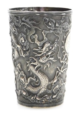 A Hung Chong silver beaker, repousse decorated with dragons chasing a flaming pearl, with a circular reserve engraved with a coronet and monogram, engraved to base Schnitzler S Kasino 1900-01, no 282, two character and HC marks, 2.87oz, 8.5cm high. - 4