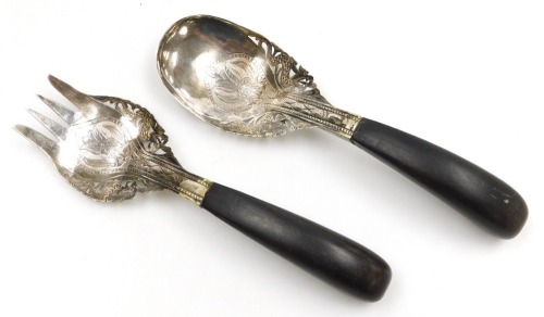 A Malaysian serving fork and spoon set, white metal, chased and pierced with stylised flowers and dragons, with curved horn handles, 21cm long.