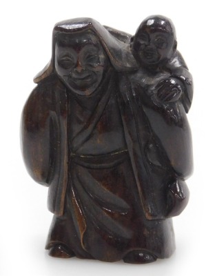 A contemporary Japanese style hardwood netsuke, carved as an elderly man with a boy upon his shoulder, 5cm high.