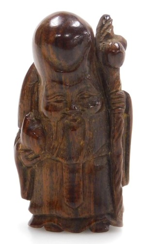 A contemporary Japanese style hardwood netsuke of Fukurokuju, modelled standing holding a peach in one hand, a staff in the other, 5cm high.