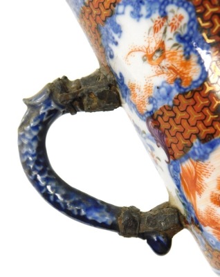 A Qianlong famille rose porcelain tankard, with a dragon handle, painted with reserves of figures in a garden, birds and flowers, within a blue floral ground, 11cm high, together with an early 19thC blue and white, and clobbered chinoiserie saucer, 14cm w - 10