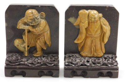 A pair of late 19thC Qing dynasty soapstone bookends, carved with immortals on a cloud ground, and carved base, 11cm high. - 2