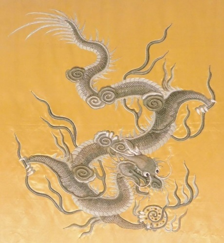 A late 19thC Chinese stump work embroidery, on gold silk, of a four claw dragon, in white and silver silk, holding a flaming pearl, 46cm high, 41cm wide.