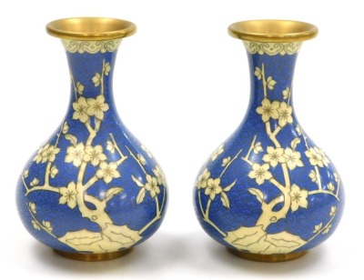 A group of 20thC Chinese cloisonne enamel wares, comprising a pair of blue ground vases decorated with prunus blossom, 12cm high, pair of white ground vases, decorated with peonies, 10cm high, and a pair of floral decorated red ground bowls, 15cm wide. (6 - 2