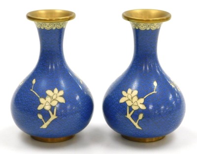 A group of 20thC Chinese cloisonne enamel wares, comprising a pair of blue ground vases decorated with prunus blossom, 12cm high, pair of white ground vases, decorated with peonies, 10cm high, and a pair of floral decorated red ground bowls, 15cm wide. (6 - 4