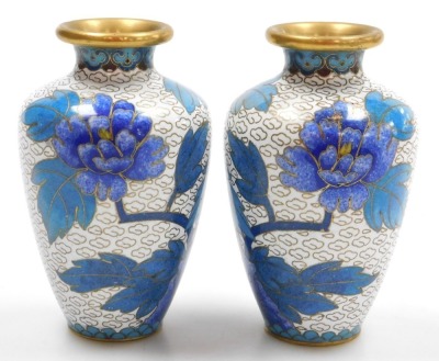 A group of 20thC Chinese cloisonne enamel wares, comprising a pair of blue ground vases decorated with prunus blossom, 12cm high, pair of white ground vases, decorated with peonies, 10cm high, and a pair of floral decorated red ground bowls, 15cm wide. (6 - 8