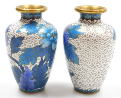 A group of 20thC Chinese cloisonne enamel wares, comprising a pair of blue ground vases decorated with prunus blossom, 12cm high, pair of white ground vases, decorated with peonies, 10cm high, and a pair of floral decorated red ground bowls, 15cm wide. (6 - 9