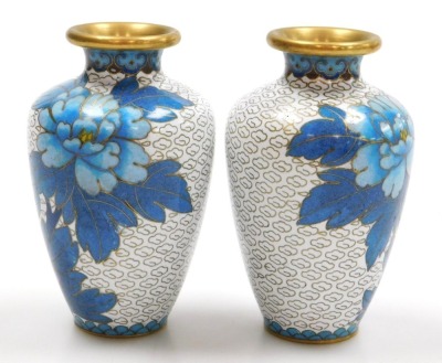 A group of 20thC Chinese cloisonne enamel wares, comprising a pair of blue ground vases decorated with prunus blossom, 12cm high, pair of white ground vases, decorated with peonies, 10cm high, and a pair of floral decorated red ground bowls, 15cm wide. (6 - 10