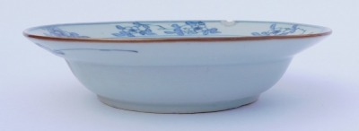 A group of Qing dynasty blue and white porcelain, 18thC and later, comprising a dish decorated with a river landscape, two plates decorated with flowers, and a dish decorated with flowers. (4, AF) - 15