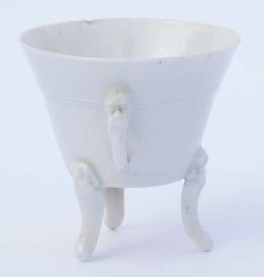 An 18thC Qing dynasty blanc-de-chine porcelain libation cup, of twin handed, tapering form, raised on three mask capped, scroll feet, ex Royal Worcester Porcelain Works Museum label, inventory number 8978, 7cm high. (AF) - 4