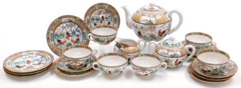 A 20thC Chinese porcelain famille rose part tea service, decorated with roosters, within a border with reserves decorated with fruit and flowers, comprising teapot, cream jug, sucrier, six tea cups, saucers and tea plates.