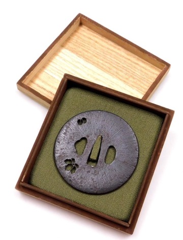 An Edo period iron tsuba, of circular form, with pierced decoration of a flower, and interlocking circles, 7.5cm wide.