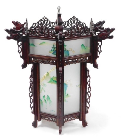 A 20thC Chinese hardwood lantern, of hexagonal form, inset with glass panels, painted with watercolour landscapes, 55cm high.