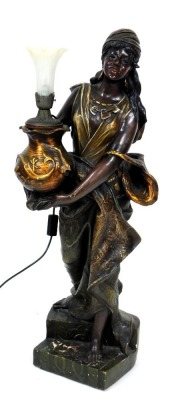 A late 19thC figural plaster torchere, of an exotic peasant woman, holding an oriental vase, raised on a stepped base, with a later electric light fitting, 100cm high.