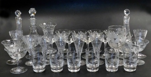 A group of Edwardian and later cut glass table wares, including six wine glasses, with star etched banded decoration, floral engraved champagne coupes, cut glass decanter and stopper, and two jugs and stoppers. (qty)