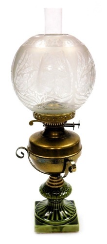 An early 20thC duplex brass and pottery oil lamp, with a brass reservoir, glass chimney and floral etched glass shade, 55cm high.