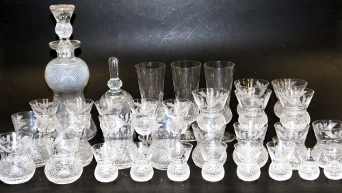 An Edinburgh Crystal Thistle Pattern suite of table glassware, including champagne flutes, red and white wine glasses, whisky and water tumblers, liqueur glasses, a stirrup cup, and a decanter. (34)